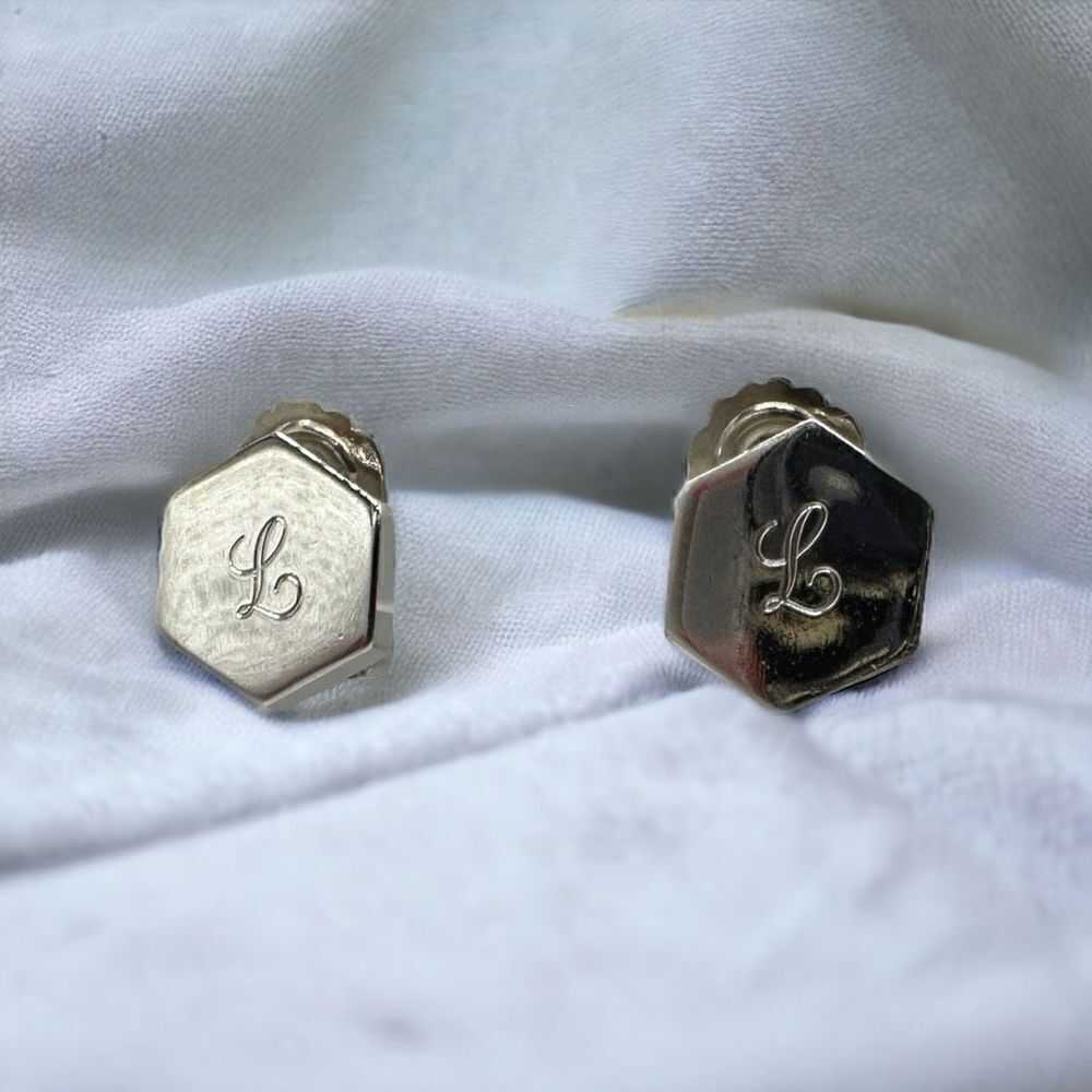 CORO silver toned hexagon shaped clip on earrings with the letter L